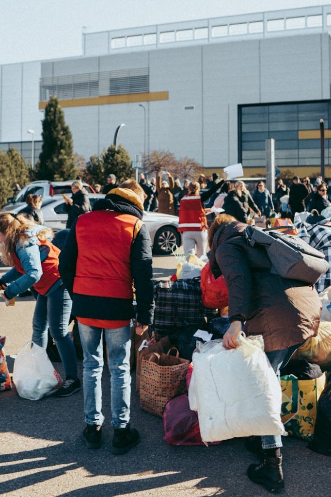 people-on-street-wearing-winter-clothes-11319517 Group of individuals sorting donations outside in Vilnius, Lithuania on a sunny day.